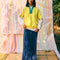 model wearing relaxed fit color block sweatshirt with yellow body, white sleeves, teal zipper placket and navy collar with a denim skirt