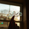 model holding cornflower 'pyrex' inspired suncatcher sticker against the window
