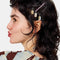 model wearing black and pink bobby pins and tin with dangling kitty charm