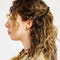 model wearing set of two large black curved hair clips with yellow rhinestones