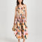 model wearing pink midi dress with curved hem, corset bodice, and colorful abstract print