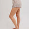 side view of model wearing cream and brown plaid crinkle boxer shorts