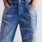 up close of model wearing medium denim barrel jeans with faded sun print design