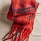 folded red scarf with pink and purple stripes and beading detail