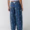 back view of model wearing navy pinstripe balloon lounge pants with white dainty floral print