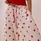 up close of model wearing white relaxed fit PJ pants with different shaped red dots