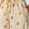 up close of model wearing cream pinstripe balloon lounge pants with yellow dainty floral print