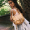 model carrying tan saddle bag crossbody with silver hardware