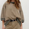 model wearing brown oversized short sleeve sweatshirt with olive green trim