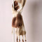 cream brown and tan oversized scarf with thick fringe on the end hanging on a cream bar 