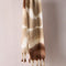cream brown and tan oversized scarf with thick fringe on the end hanging on a cream bar