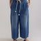 model wearing light indigo pull on jeans with elastic tie waist and patch front pockets