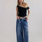 model wearing light indigo pull on jeans with elastic tie waist and patch front pockets
