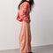 side view of model wearing dessert pink barrel pants