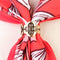 up close of brass floral scarf slide + ring on a scarf