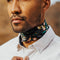 model wearing black bandana with gold, pink, & green flowers