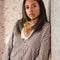 model wearing cream background bandana with orange, green, gold and pink with chocolate brown outlines around their neck