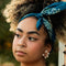 model wearing dark and medium blue, cream tiled square bandana