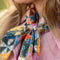 model wearing colorful patchwork square bandana around their neck