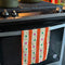 pale yellow and orange striped tea towel with green and pink dots on an oven handle