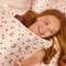model holding light pink cherry print satin pillowcase on a pillow