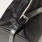 up close of buckle on black nylon barrel handbag with leather buckle shoulder strap and trim