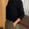 Side view of model wearing black long sleeve cotton tee