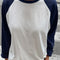 model wearing white relaxed fit raglan tee with navy sleeves