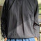 model wearing black pin-tucked blouse with button neck opening