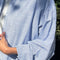 up close of model wearing relaxed fit blue and white vertical stripe button front shirt