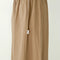 up close of model wearing khaki parachute pants with elastic waist and side pockets