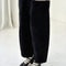 side view of model wearing black corduroy arc pants