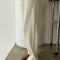 side view of model wearing cream waffle knit pants with elastic waist and side pockets