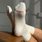 red logo on the bottom of model wearing white socks with thin pale yellow stripes