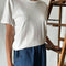 model wearing white organic cotton tee with slight distressing on the sleeves and neckline