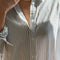 up close of model wearing white relaxed fit button front shirt with side vents, collar and denim blue stripes
