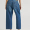 back view of model wearing blue cropped button jeans with white bleach splatters