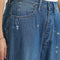 up close of model wearing blue cropped button jeans with white bleach splatters