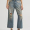 model wearing gritty medium wash loose crop button fly jeans with distressing on the legs