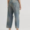 back view of model wearing gritty medium wash loose crop button fly jeans with distressing on the legs