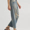 side view of model wearing gritty medium wash loose crop button fly jeans with distressing on the legs