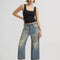 model wearing gritty medium wash loose crop button fly jeans with distressing on the legs