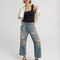 model wearing gritty medium wash loose crop button fly jeans with distressing on the legs