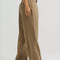 side view of model wearing tan brown slouch chino pants with pleated front
