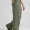 side view of model wearing olive green slouch chino pants with pleated front