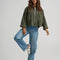model wearing olive green cropped utility jacket with large patch pockets on the front