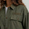 up close of model wearing olive green cropped utility jacket with large patch pockets on the front
