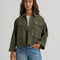 model wearing olive green cropped utility jacket with large patch pockets on the front