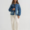 model wearing patched denim chore jacket with a mix of light and dark wash denim and front patch pockets
