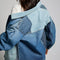 backview of model wearing patched denim chore jacket with a mix of light and dark wash denim and front patch pockets